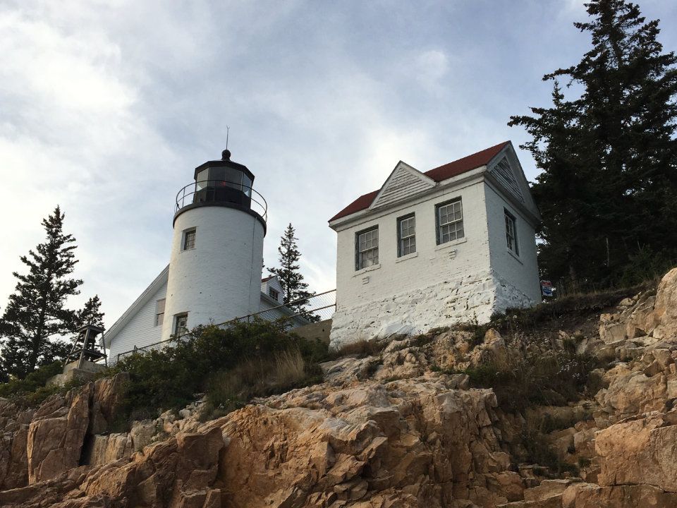 White lighthouse and keeper's house atop a rocky coastal bluff