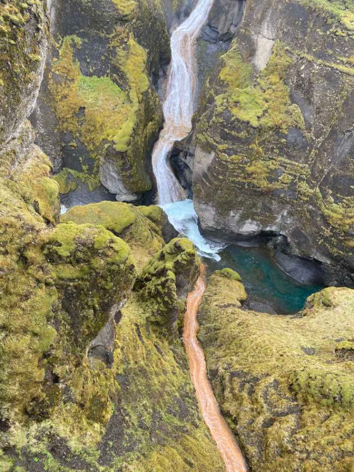 Rust-colored and turquoise streams converging in Fjaðrárgljúfur Canyon