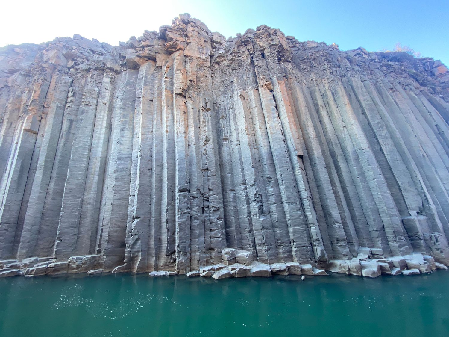 Basalt column cliff towering above a turquoise river