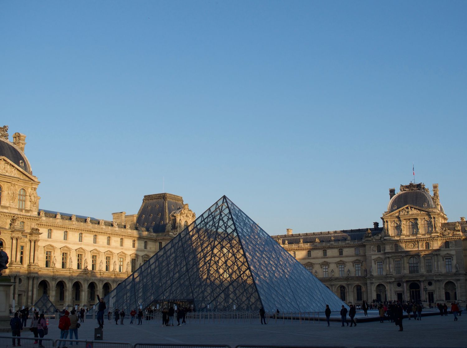 Louvre Pyramid and palace courtyard at golden hour